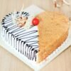 Delicious heart-shaped butterscotch cake with whipped cream and fresh cherries